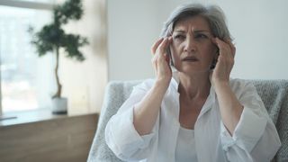 Elderly senior woman suffering from migraines and headaches