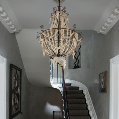 limewashed walls in stair landing with big light fixture