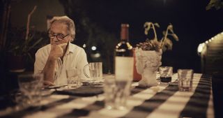 Larry Fink at a dinner table, in a still from the film Fink