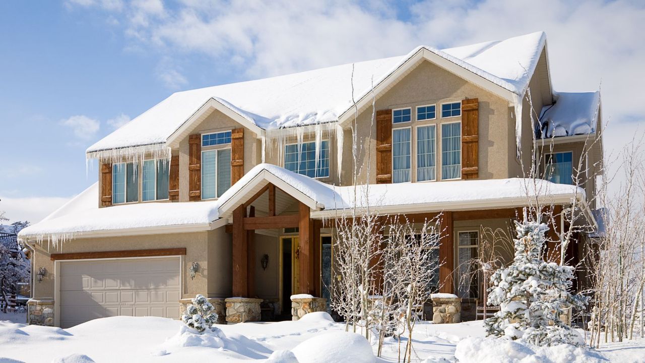 A house covered in snow with icicles on the eaves