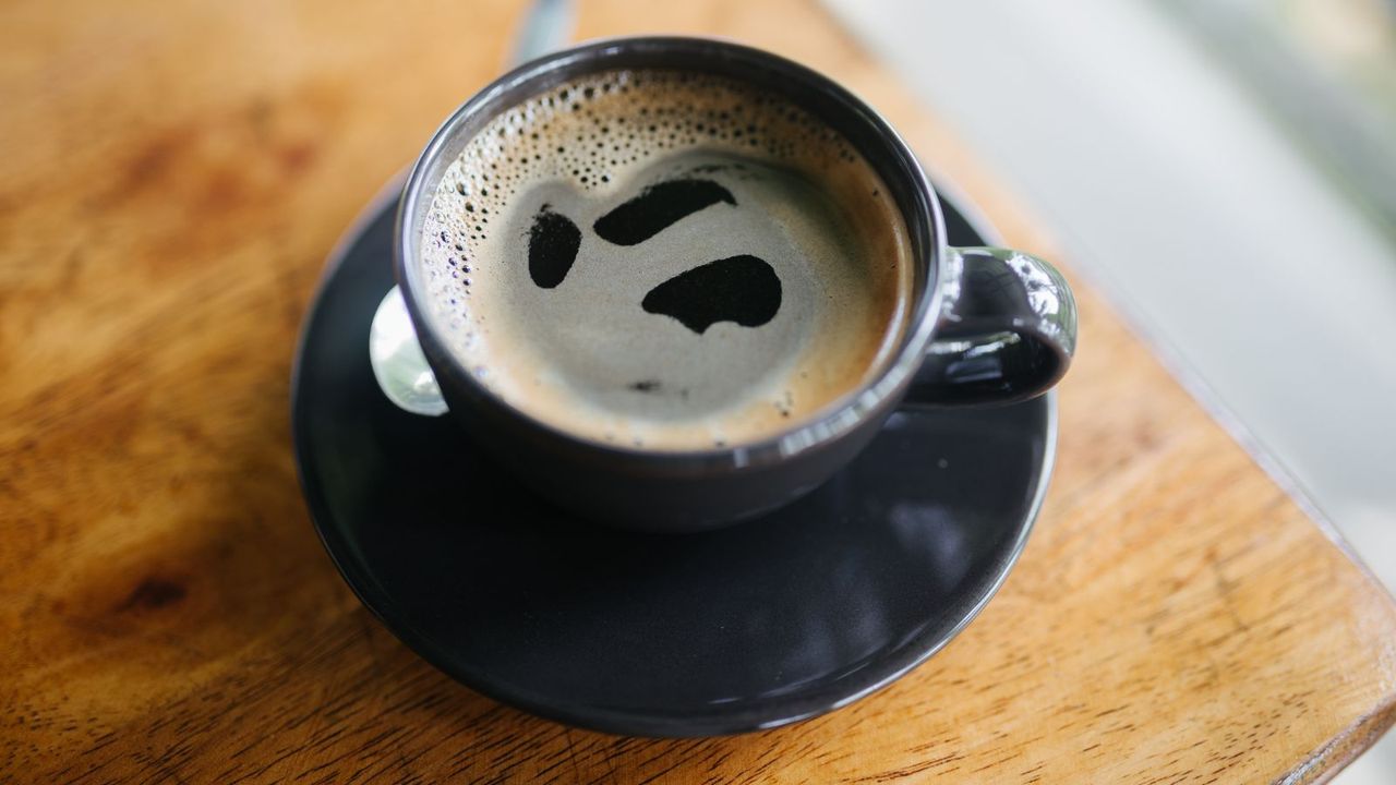 how to make an Americano: an Americano on a wooden table in a cup and saucer