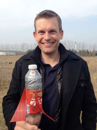 ESA astronaut Andreas Mogensen holding a student bottle rocket ready to launch with one of his LEGO iriss minifigures.