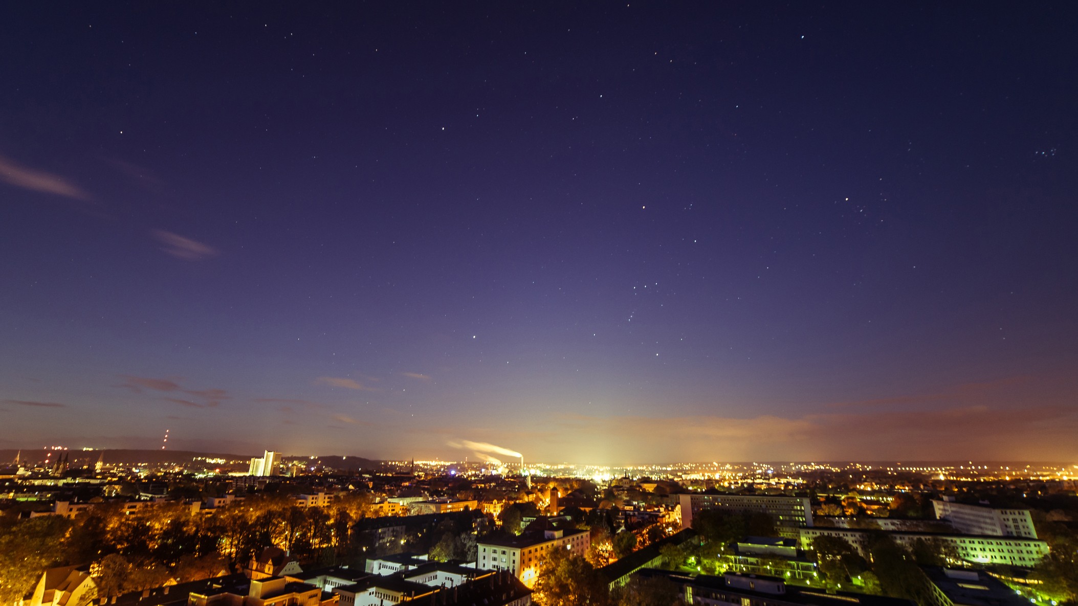 uma paisagem urbana à noite com estrelas brilhando no céu acima.