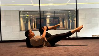 Personal trainer Aimee Victoria Long performing a single-leg stretch