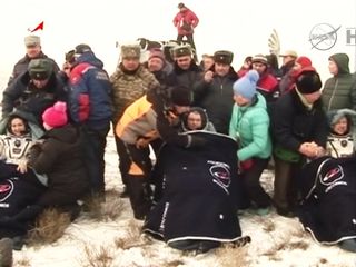 Russian cosmonauts Elena Serova (left), Alexander Samokutyaev (center) and NASA astronaut Barry Wilmore are recline in blanket-covered chairs after landing on Earth on March 11, 2015 EDT (March 12 local time) on the steppes of Kazakhstan. The trio spent 1