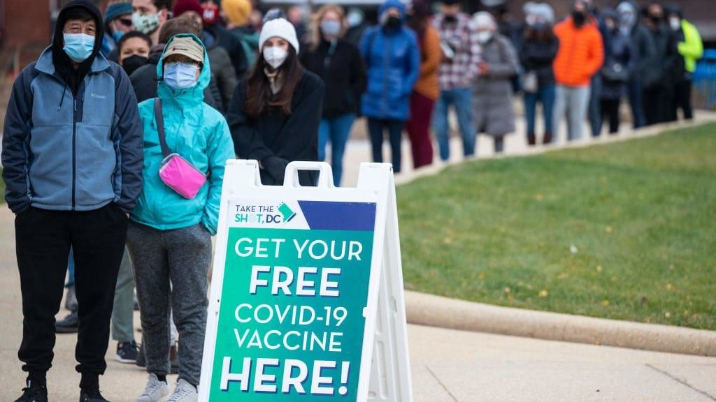 People wait in line to get their COVID-19 vaccine shots.