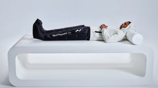 A man led down wearing the Normatec Premier boots from Hyperice