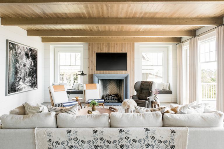 TV wall idea in a Living room with mostly muted colors and natural wood with pops of mustard and patterns