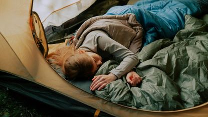 A woman sleeping in a tent