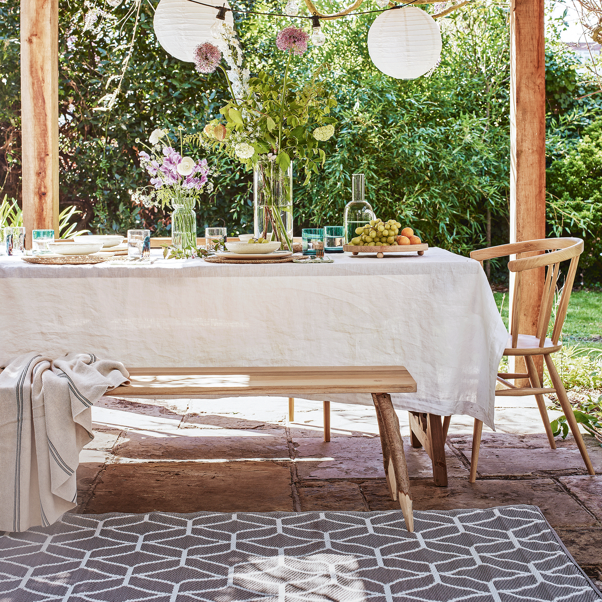 outdoor table under a pergola on a rug