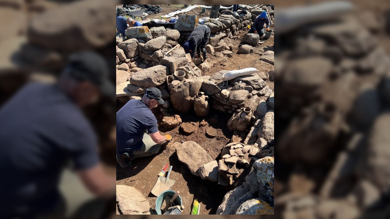This photo shows a close up of archaeologists unearthing storage jars, alongside other artefacts, in the ruins of an ancient farmstead found in northern Israel.
