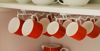 inside organized kitchen cabinet with hanging rails for mugs and cups to maximize space