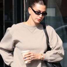 Hailey Bieber was seen out for a Blue Bottle Coffee run wearing a taupe crewneck sweatshirt paired with Levi's straight jeans and pointed-toe shoes. 