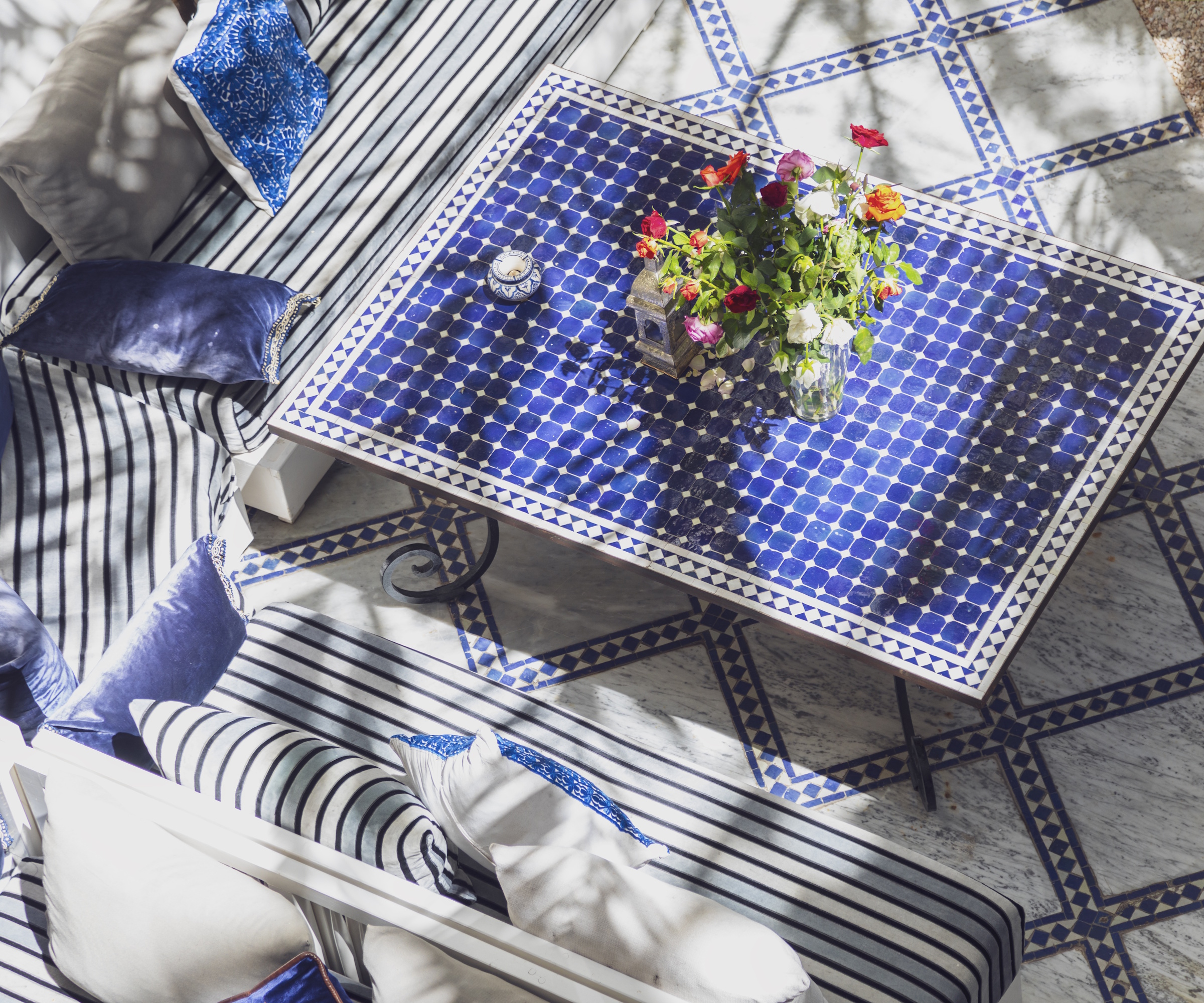 Moroccan courtyard, table with blue tiles and cushioned sofas