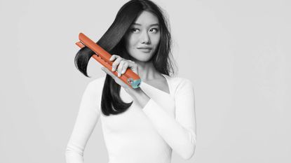 Dyson Corrale being used on a woman's hair in the Ceramic Pop colour scheme