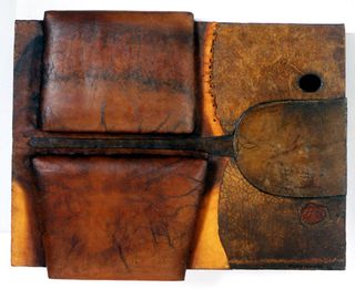 A piece of leather artwork constructed of several sections of leather, some standing proud of the surface