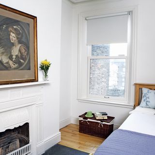 white bedroom with fire place and painting