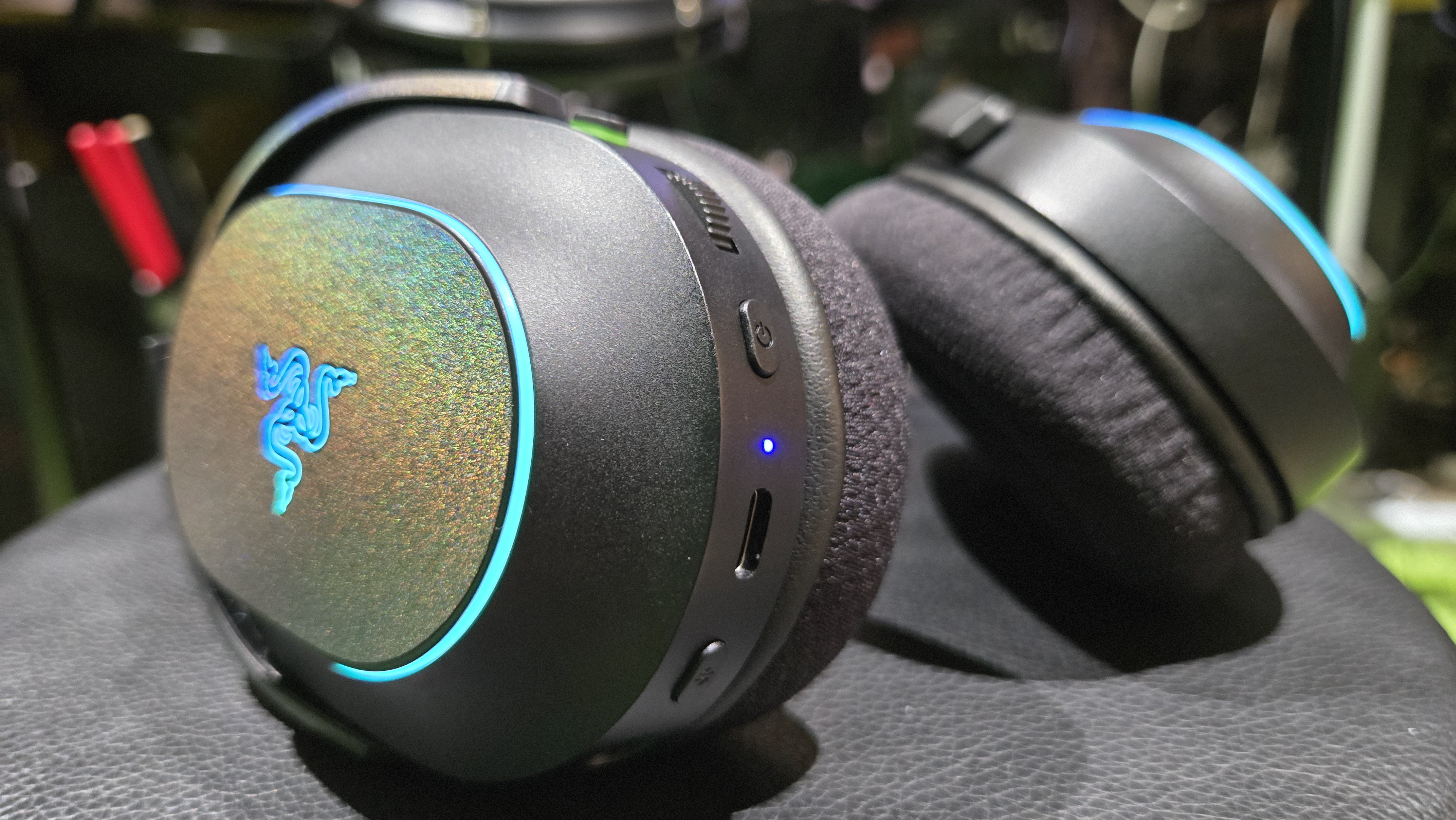 The Razer Barracuda X Chroma wireless gaming headset with a colorful finish on a chair.