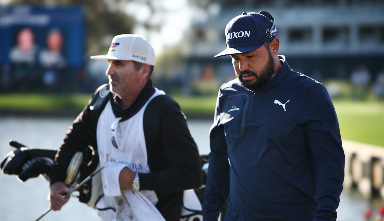 JJ Spaun walks with his caddie with his head down