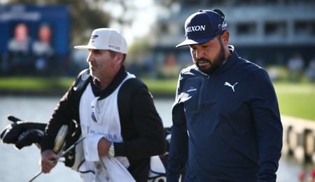 JJ Spaun walks with his caddie with his head down