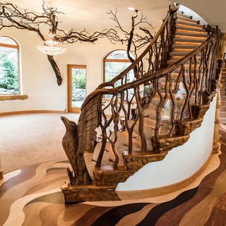 room with tree shaped wooden stairway white walls and semiarched windows