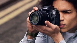 The Canon EOS 80D DSLR being held to someone's eye