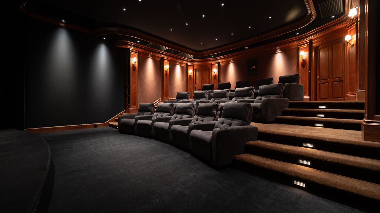 Home theater Hahn theater showing seating, lighting sconces, and stairs