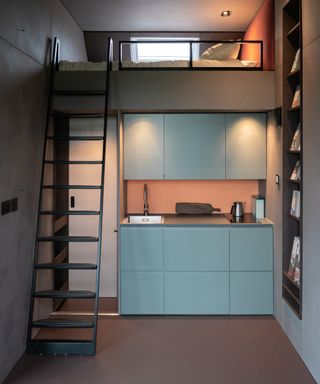 Inside of a small cabin showing small kitchen space and bunk bed