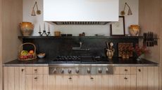 A kitchen with white walls, paneled wooden cabinetry, and granite countertops