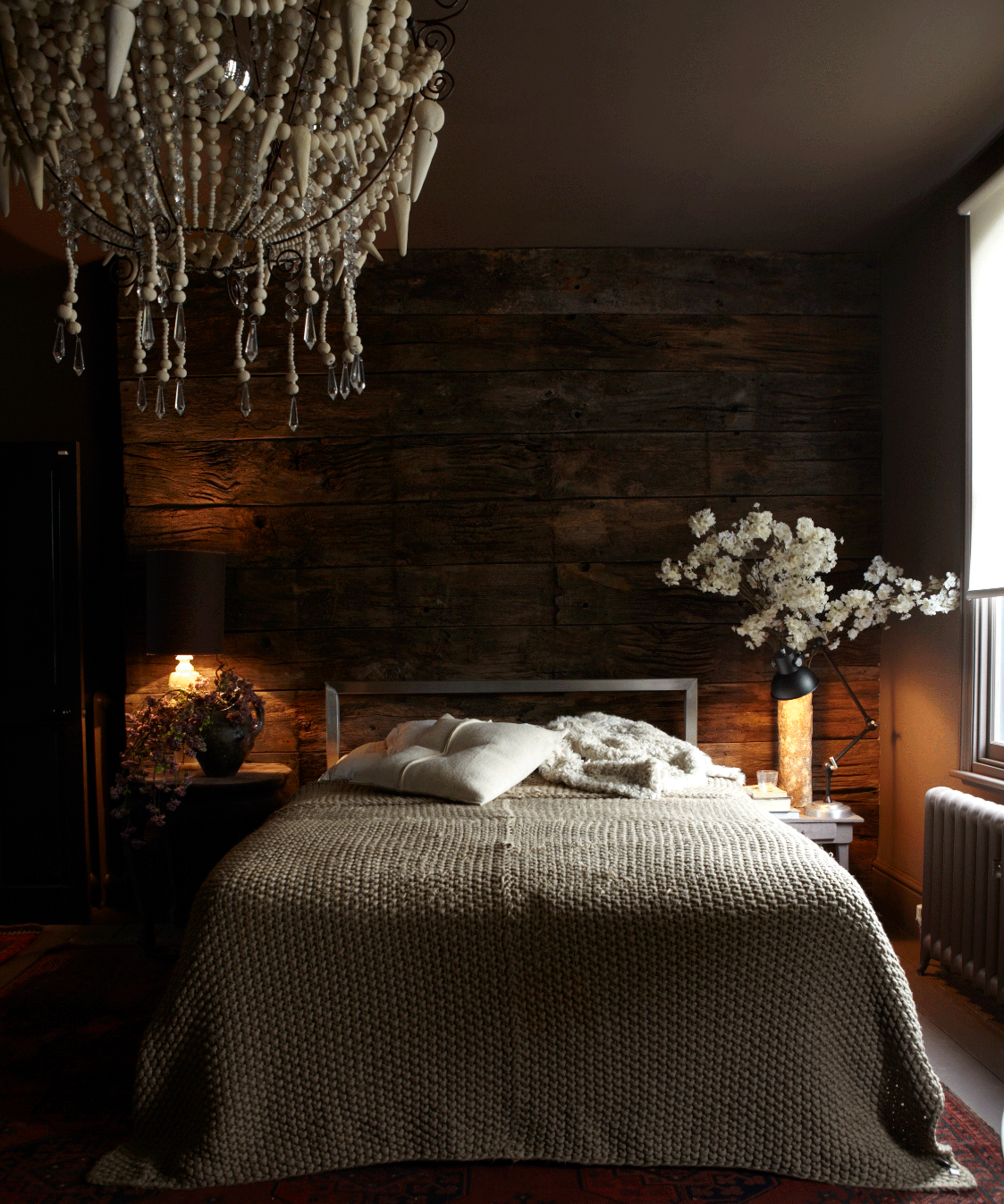 Dark bedroom with beaded chandelier and painted ceiling