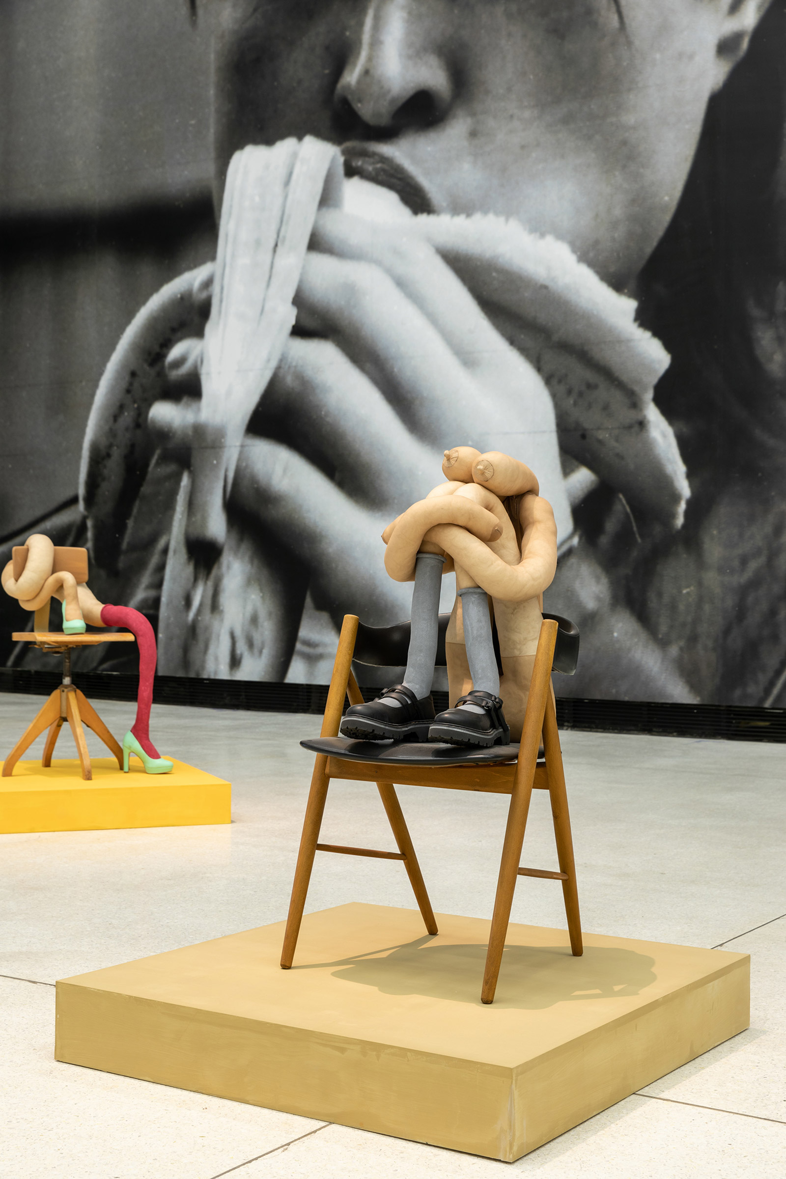 Abstract sculptures resembling human legs on chairs