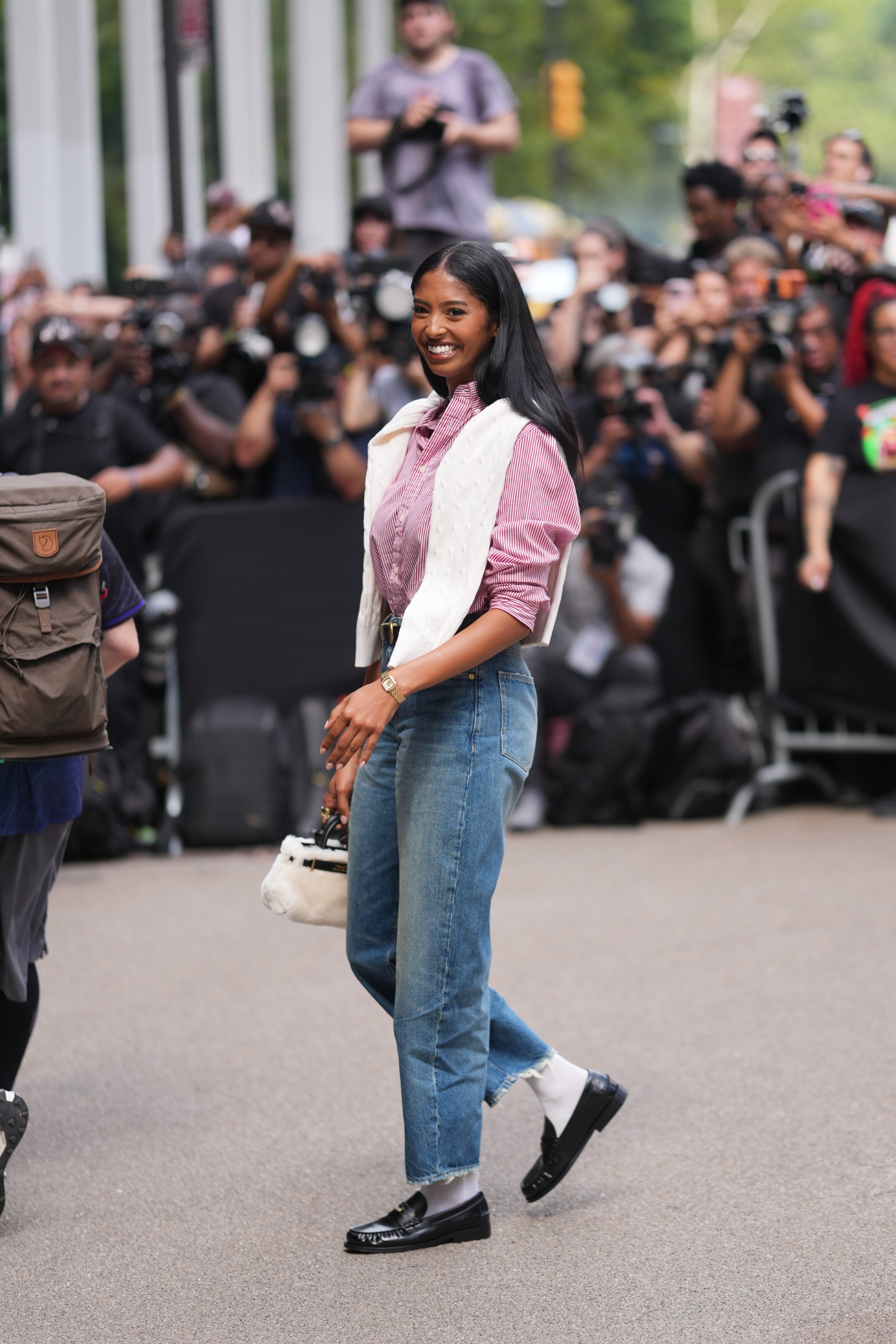 woman wearing striped button down shirt cable sweater jeans and socks with loafers