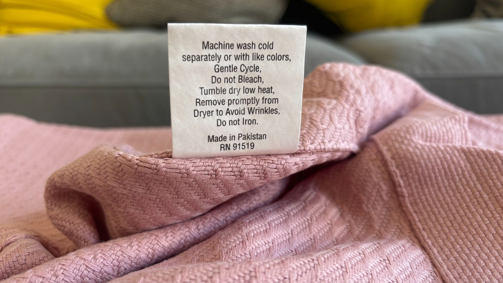 A close-up look at the care label of a cotton blanket.