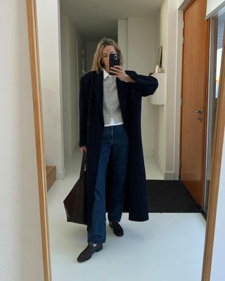 Anouk Yve in cardigan and jeans.