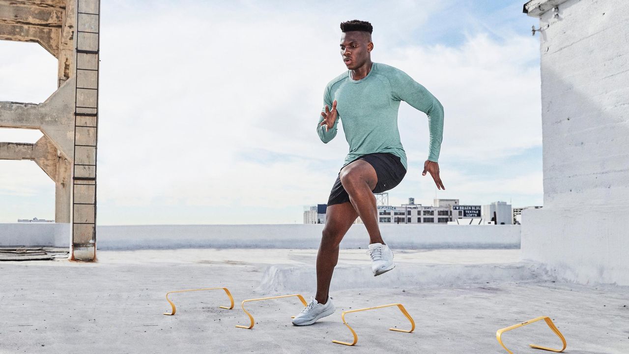 A man jumping over exercise cones wearing some of the best workout clothes for men