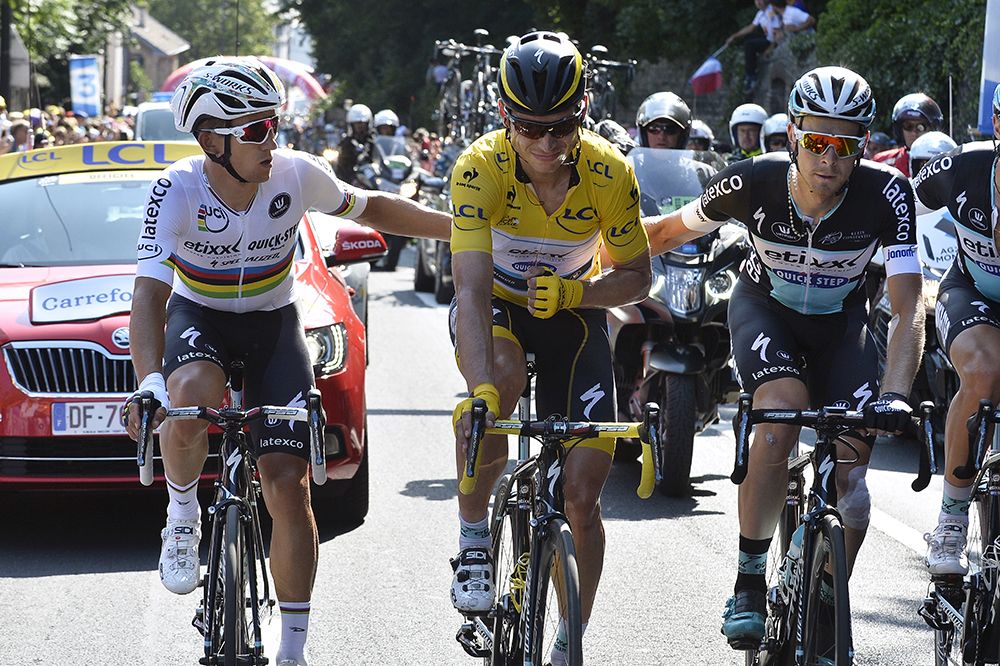 Etixx-Quickstep's Tony Martin is helped to the finish