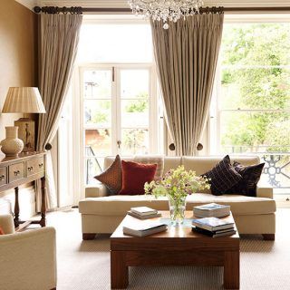 neutral living room with wall to wall window and pale curtains