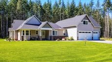 A suburban house with a large lawn that backs onto woodland