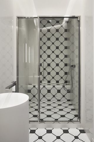 black and white shower with shower bench and glass doors
