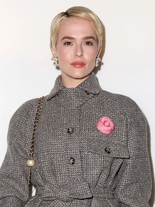 A woman, Zoey Deutsch, with a blonde pixie cut.