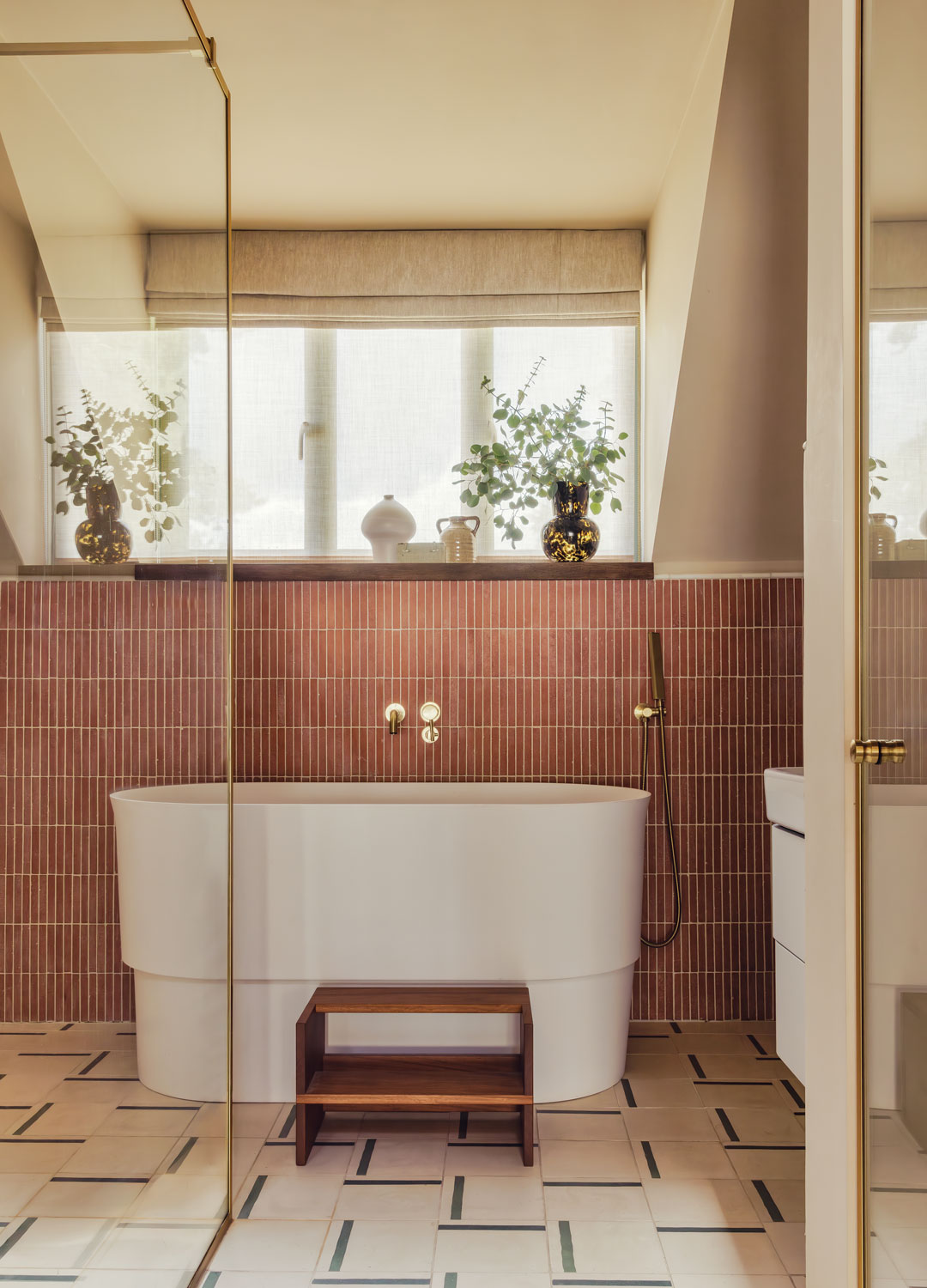 bathroom with compact bath and red slimline vertical wall tiles