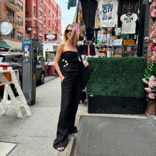 Fashion editor Natalie Cantell on the street in New York City wearing Loewe sunglasses, flat leather Mango flip-flops sandals, the SIR. Dorian top with crochet detail, and matching black wide-leg trousers.