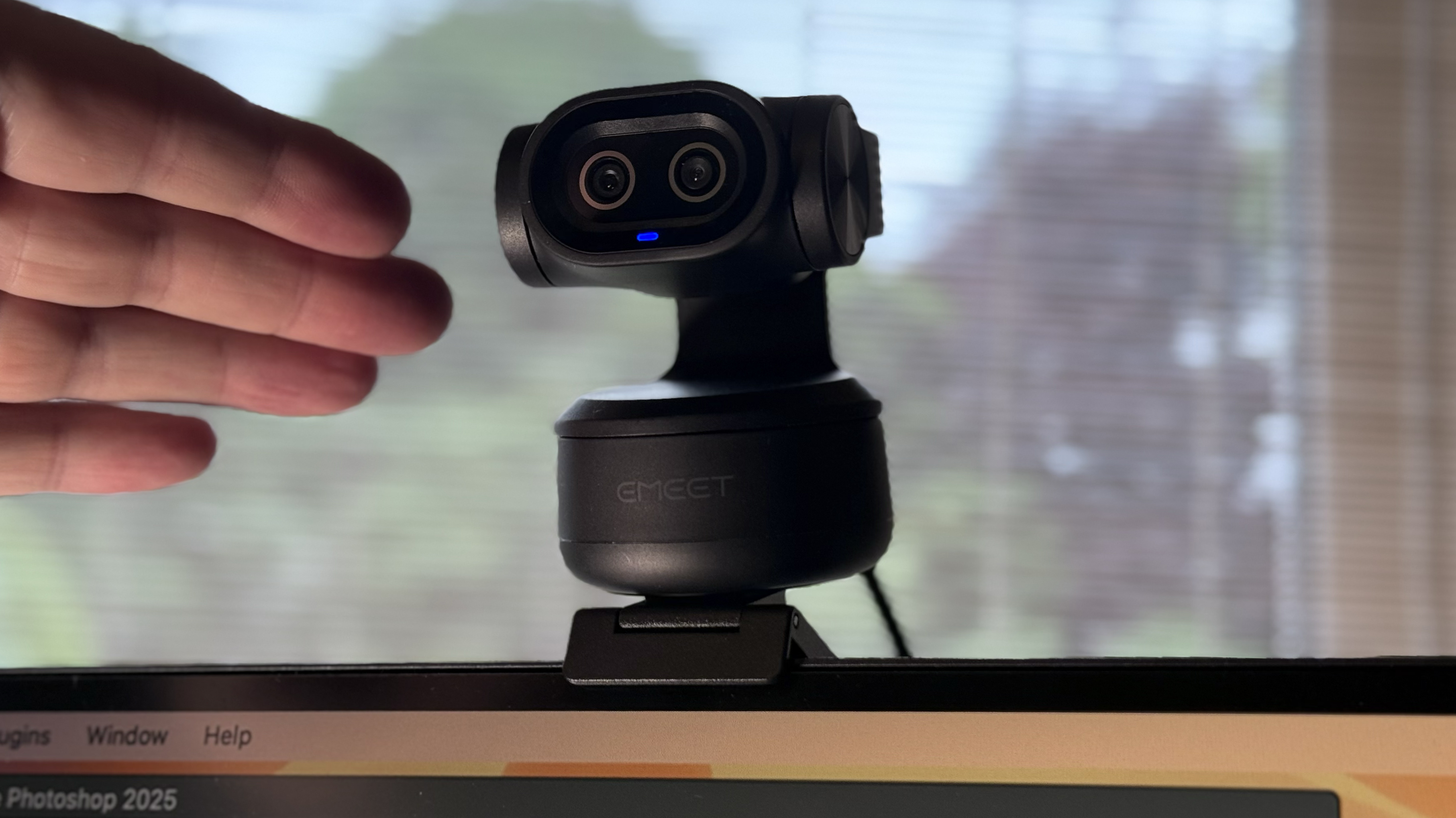 A hand points towards the lenses on the small black body of the Pixy webcam