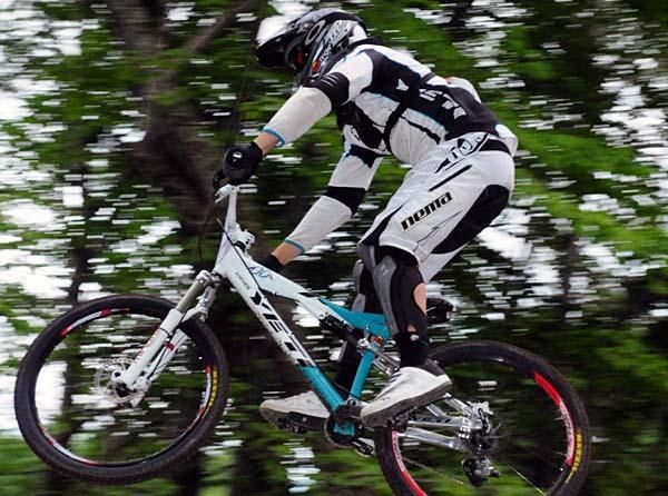 A Yeti racer flies over the wooden bridge.