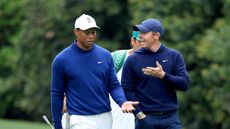 Tiger Woods and Rory McIlroy are engaged in conversation during a practice round at The Masters in 2023