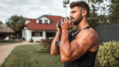 A man performing a dumbbell goblet squat during an outdoor workout 