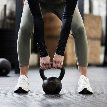 A woman doing 30 minute kettlebell workouts in the gym