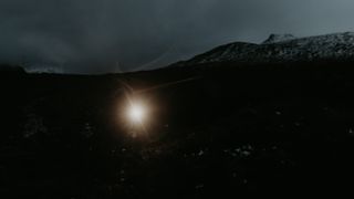 Keri Wallace running in the dark, only her headlamp is visible