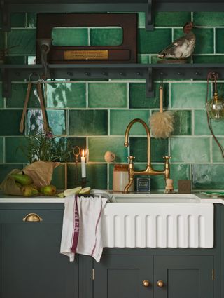 Matt black base cabinets and different shades of green tiles