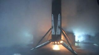 falcon 9 rocket first stage landing on a drone ship in the dark.